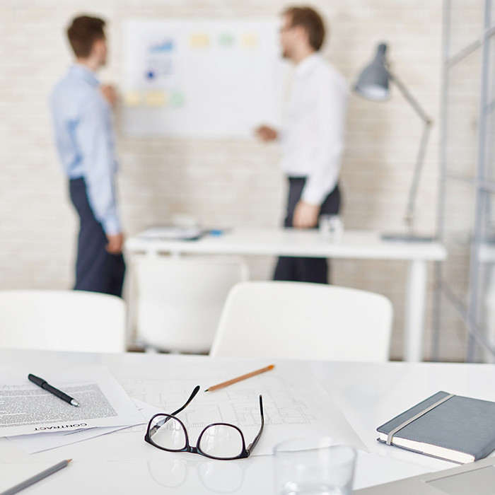 Empty workplace in office with businessmen interacting on background